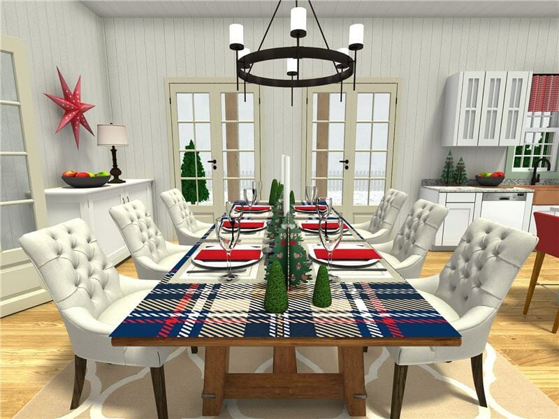 3D-rendered image of a festive dining room set for a holiday meal. A rustic wooden table is covered with a navy, red, and white plaid table runner and decorated with small green Christmas tree figurines. Each place setting features red napkins, white plates, and wine glasses. The room includes white upholstered chairs, double French doors, a white sideboard with a lamp and fruit bowl, and white cabinetry in the kitchen area.