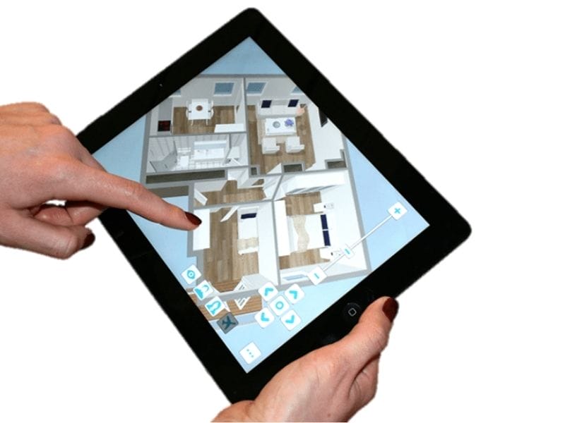 Close-up of a person using a tablet to view and interact with a 3D floor plan in the RoomSketcher app. The screen shows a furnished home layout with bedrooms, bathrooms, and living areas. On-screen controls for navigation and zoom are visible, and the person is using their finger to point at the design.