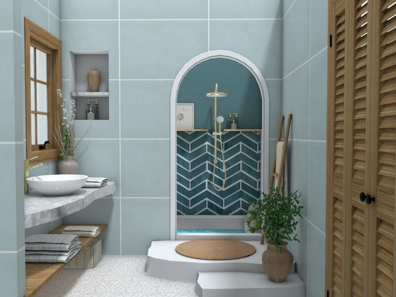 3D-rendered modern bathroom with soft blue tile walls, a raised shower area framed by an arched doorway, and bold chevron-patterned blue tiles inside the shower. The space features a round vessel sink on a floating stone countertop, wooden shelving with towels, a potted plant, and natural wood accents, including a window frame and louvered cabinet doors.
