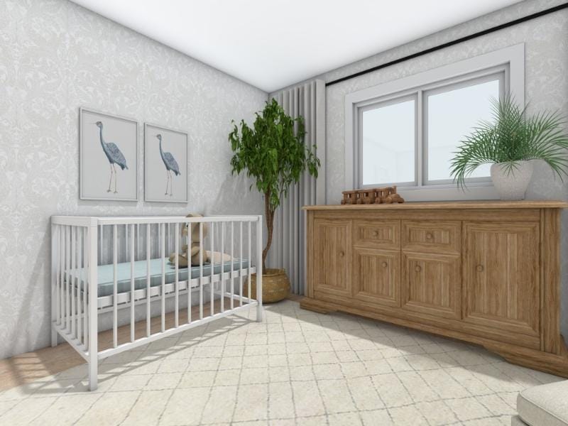 Bright nursery interior with a white crib holding a teddy bear, placed against a patterned wallpapered wall. Above the crib are two framed bird prints. A large potted plant stands in the corner next to a wooden dresser with paneled doors, topped with a toy train and a potted plant. A window with curtains brings in natural light, and a light patterned rug covers the floor.