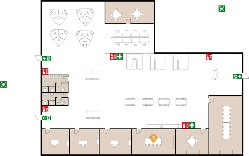 Evacuation floor plan of an open-plan office showing multiple work areas, meeting rooms, and restrooms, with green emergency exit signs marking doors on the left and right sides of the layout. Fire extinguisher and first aid symbols are placed at several points along the main circulation areas, and a location marker highlights one workstation near the bottom center of the plan.